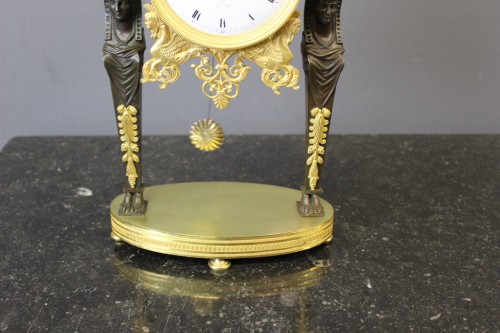 Horlogerie Pendule - Pendule portique "Retour d'Egypte" en bronze doré et patiné début XIXe