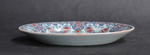 Céramiques, Porcelaines  - Assiette en faïence Rouen à décor aux lambrequins bleus et rouges