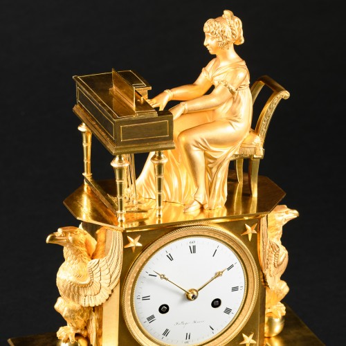 XIXe siècle - Pendule de cheminée Empire en bronze doré “L’épinettiste”