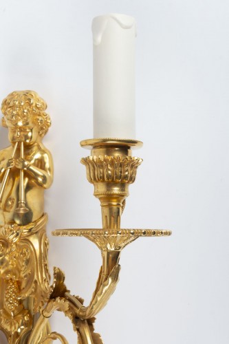Luminaires Appliques - Paire d'appliques en bronze représentant des amours soufflant dans des trompes