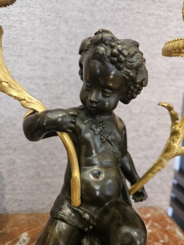 XIXe siècle - Paire de candélabres aux putti en bronze doré et patiné