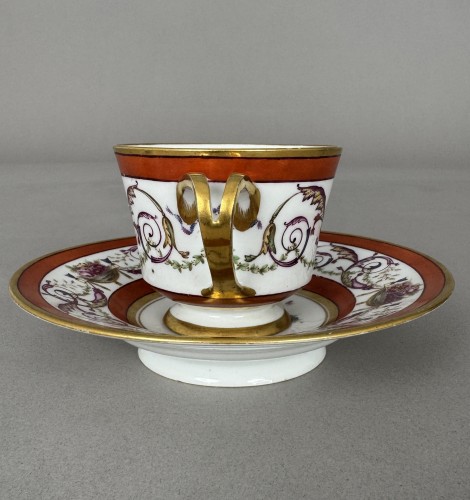 Céramiques, Porcelaines  - Tasse et soucoupe en porcelaine dure de Sèvres, fond rouge fer, décor de panier fleur