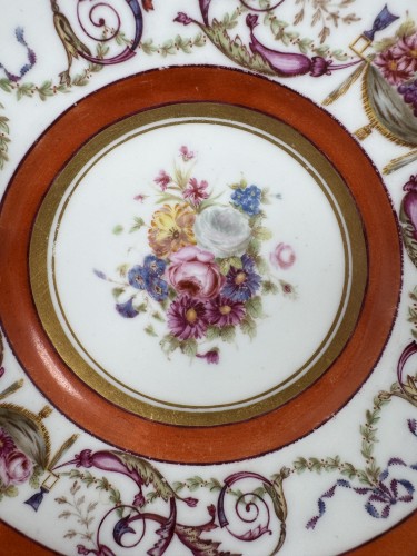  - Tasse et soucoupe en porcelaine dure de Sèvres, fond rouge fer, décor de panier fleur