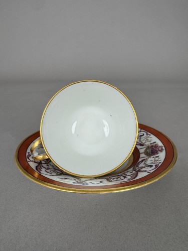 Antiquités - Tasse et soucoupe en porcelaine dure de Sèvres, fond rouge fer, décor de panier fleur