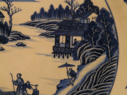 Plat en porcelaine de Chine bleu et blanc à décor de paysage lacustre vers 1800 - 