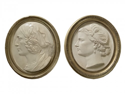 Pair of white terra cotta bas reliefs, monogrammed and dated 1869 and 1873