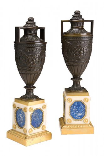 Patinated bronze urns mounted on white marble, lapis lazuli and gilt bronze bases