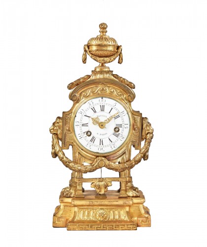 Mantel clock in the Greek taste, crowned with a vase and lion mufles