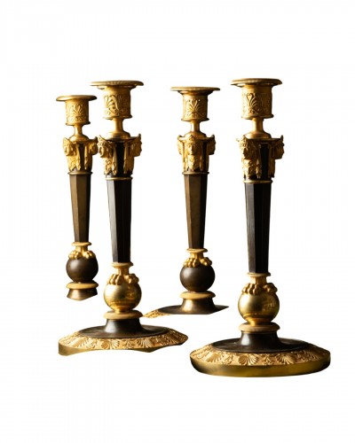 A Set of Four Empire Parcel-Gilt “Claw-Foot” Candlesticks with Antique Mask