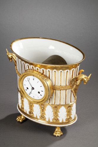 Antiquités - Pendule en forme de vase en porcelaine dorée, début du XIXe siècle
