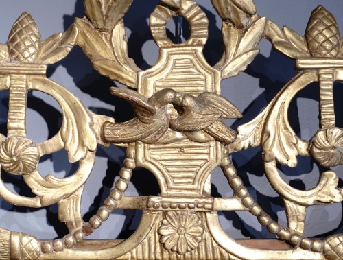 XVIIIe siècle - Miroir Louis XVI en bois doré aux attributs de « l'Amour »