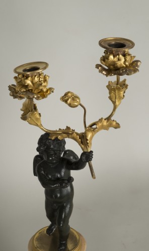 Antiquités - Paire de candélabres aux amours en bronze doré et patiné