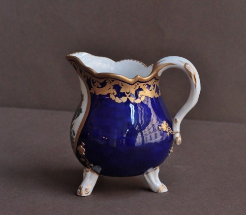 XVIIIe siècle - Pot à lait tripode en porcelaine tendre de Sèvres à fond bleu nouveau. Vers 1780-1785