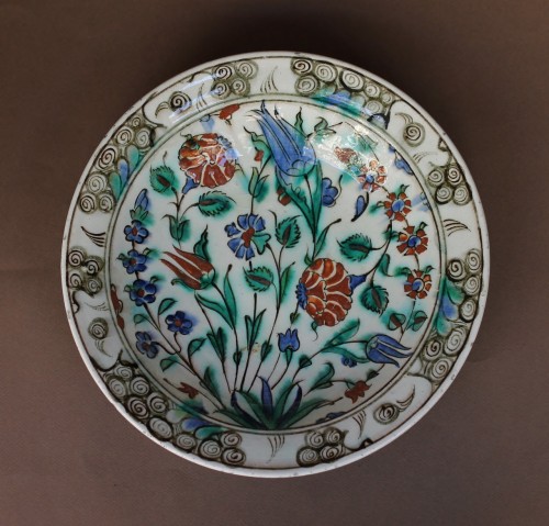 XVIIe siècle - Plat en céramique siliceuse d'Iznik à décor aux quatre fleurs. XVIIe siècle.