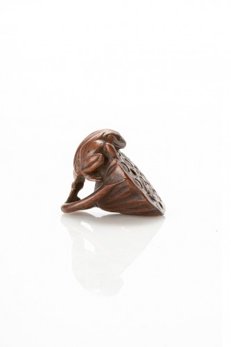 Asian Works of Art  - A Japanese boxwood netsuke of a toad on a lotus flower with a spider