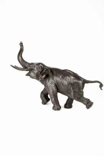 Grand okimono en bronze à patine foncée figurant un éléphant courant à trompe relevée