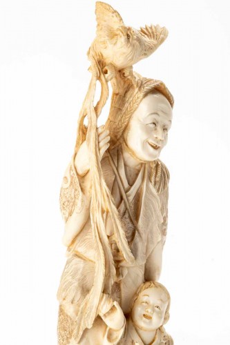 A Japanese ivory okimono depicting a hunter with an Onagadori rooster - 