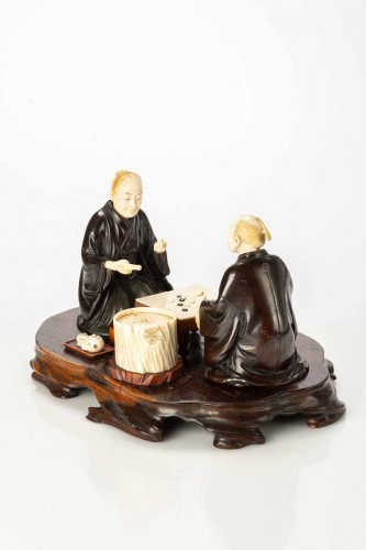  - An Ivory and bronze okimono on a wooden base depicting two Go players