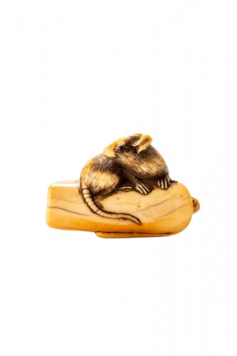 An Ivory Netsuke Depicting A Mouse Crouching On An Overturned Candle