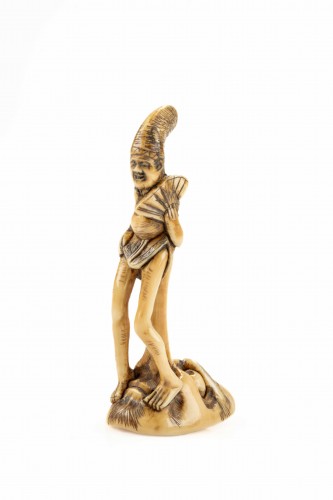 Asian Works of Art  - A shunga ivory netsuke depicting a monk seated on the nose of Tengu