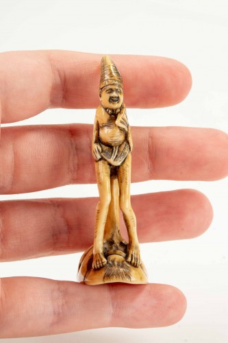 A shunga ivory netsuke depicting a monk seated on the nose of Tengu - 