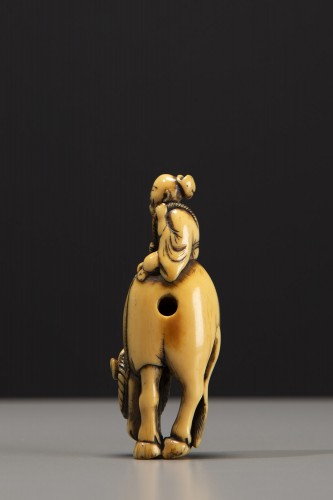 Asian Works of Art  - An ivory netsuke depicting Roshi seated on the back of a buffalo