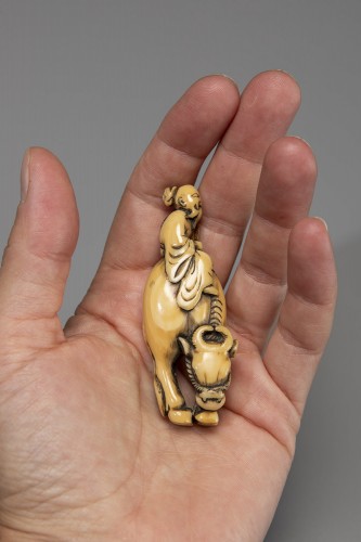 19th century - An ivory netsuke depicting Roshi seated on the back of a buffalo