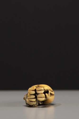 An ivory netsuke depicting Roshi seated on the back of a buffalo - 