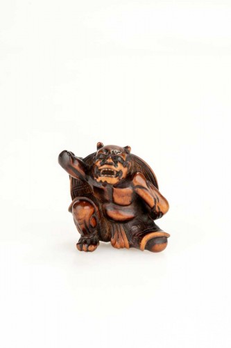 A boxwood netsuke depicting an Oni and the Setsubun festival