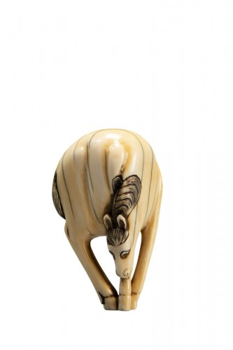 Netsuke en ivoire représentant un cheval à la tête abaissée et aux pattes réunies