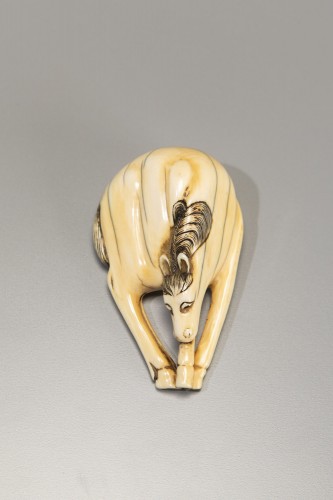 An ivory netsuke depicting a horse with lowered head and joined legs - Asian Works of Art Style 