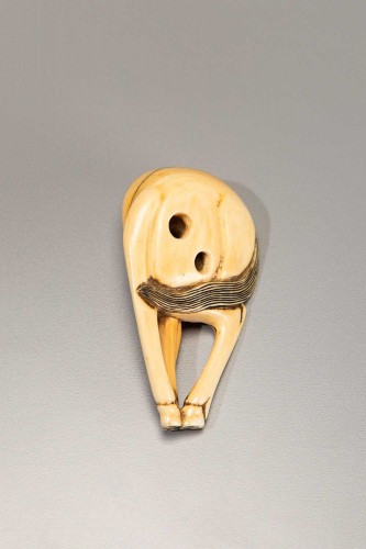 Asian Works of Art  - An ivory netsuke depicting a horse with lowered head and joined legs