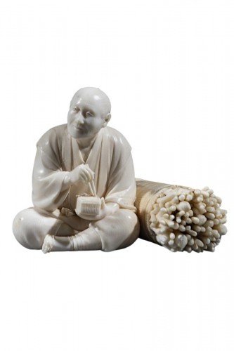 An ivory okimono depicting a woodcutter 