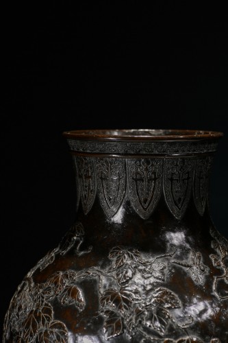  - Vase en bronze patiné à décor de vigne et d'insectes en relief, signé Sessei