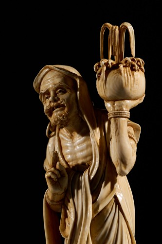 An Ivory Okimono Of A Rakan Holding A Ritual Vase, Signed Kazutoshi - 