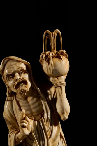 19th century - An Ivory Okimono Of A Rakan Holding A Ritual Vase, Signed Kazutoshi