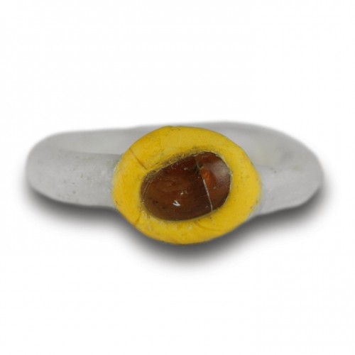 Ancient Art  - White glass ring with a yellow bezel and amber bead. Roman, 2nd-3rd Century