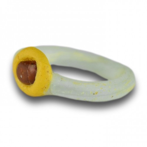  - White glass ring with a yellow bezel and amber bead. Roman, 2nd-3rd Century