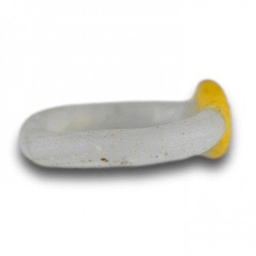Antiquités - White glass ring with a yellow bezel and amber bead. Roman, 2nd-3rd Century