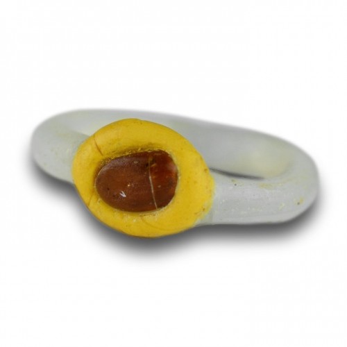 Antiquités - White glass ring with a yellow bezel and amber bead. Roman, 2nd-3rd Century