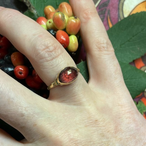 Antiquités - Gold and enamel ring set with a faceted garnet