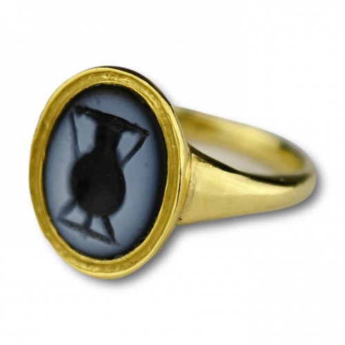 High carat gold ring set with an ancient nicolo intaglio of an amphora.  - 
