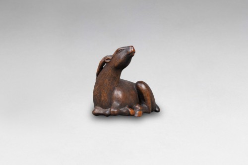  - Netsuke - daim en bois sculpté, représenté couché. Japon Edo