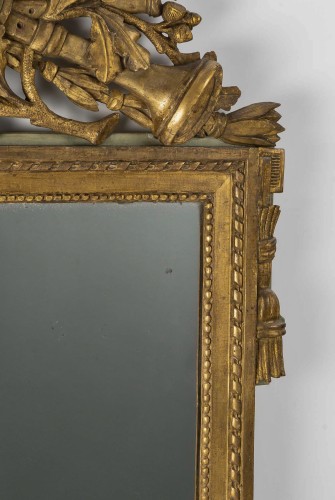 XVIIIe siècle - Miroir Louis XVI à fronton ajouré en bois doré d'attributs de musique 