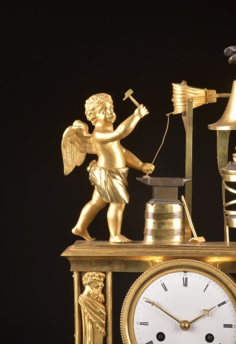 Cupidon forgeron - Pendule portique en bronze patiné et doré au feu d’époque Empire, - Horlogerie Style Empire