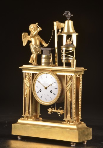 XIXe siècle - Cupidon forgeron - Pendule portique en bronze patiné et doré au feu d’époque Empire,