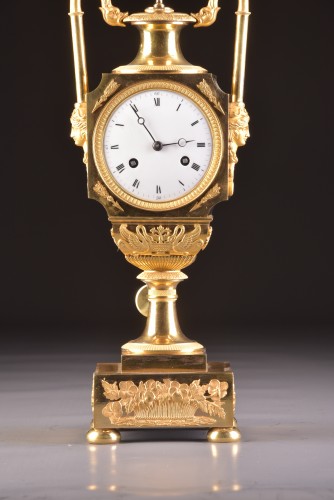 Horology  - A French fire-gilt Empire vase mantel clock