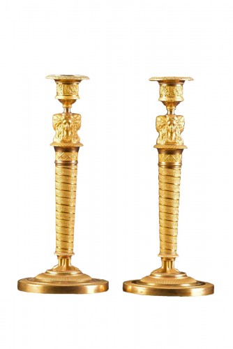 A pair of gilded bronze Empire candlesticks