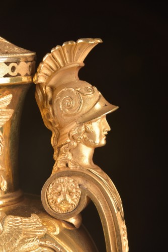 Empire - Vase pendule en plaqué or "Aux têtes de guerriers", circa 1810