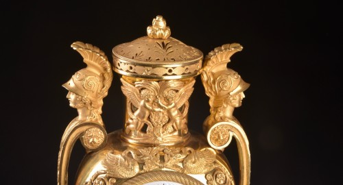 Antiquités - Vase pendule en plaqué or "Aux têtes de guerriers", circa 1810